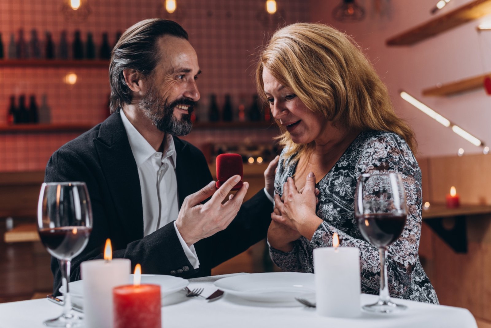 Moget par vid en middag där mannen håller fram en ringask