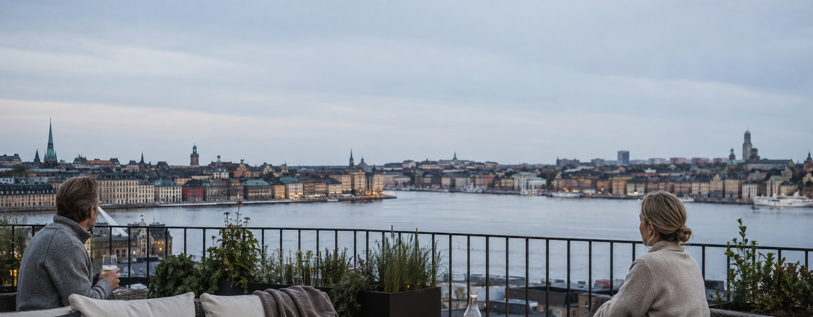 Ett moget par på en nordisk terrass med utsikt över vattnet i Sverige